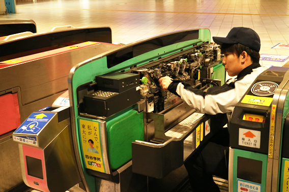 自動改札機を点検する技術員